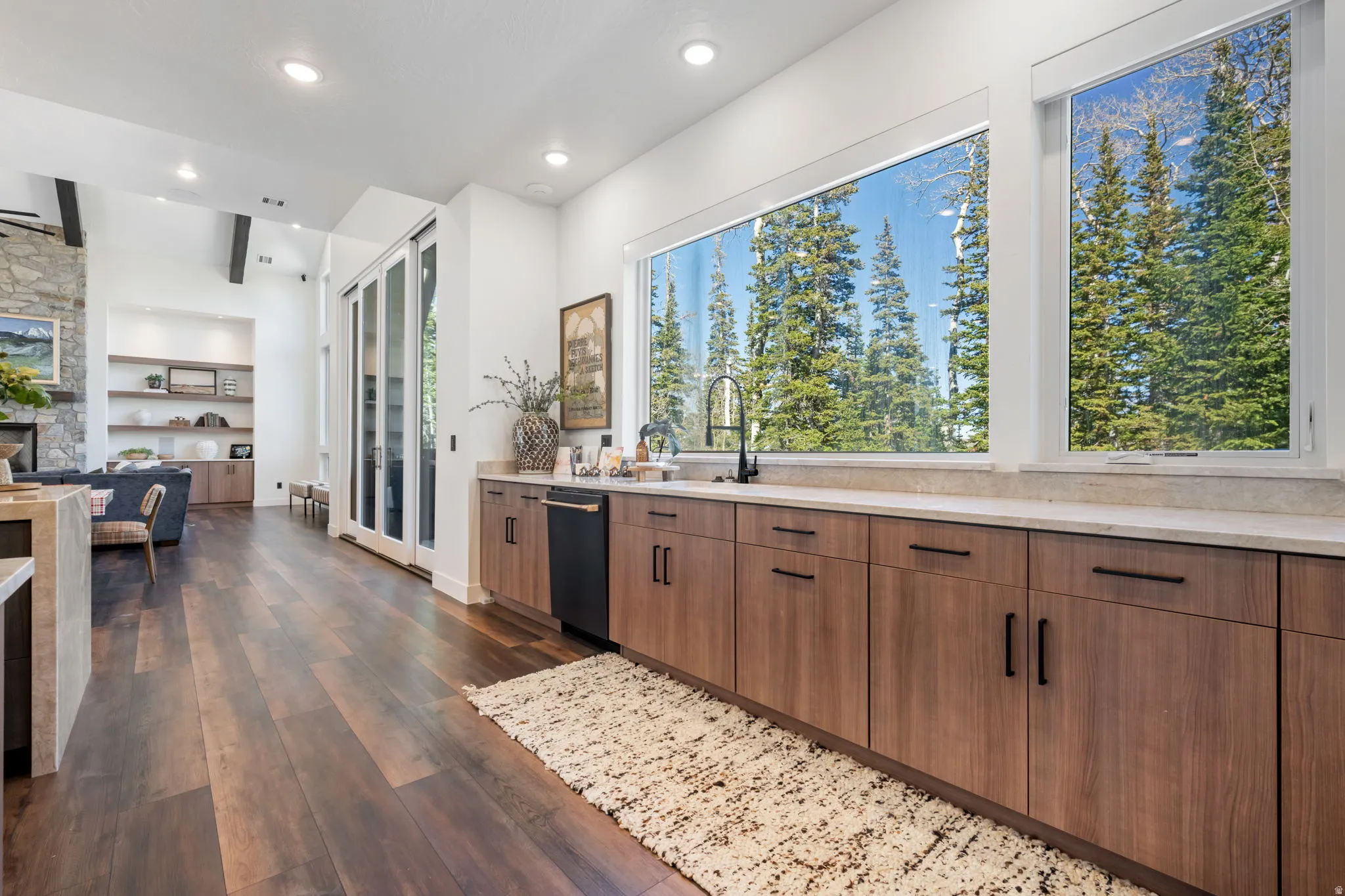 Kitchen with a fireplace, dark wood-style floors, built in shelves, light stone counters, and recessed lighting