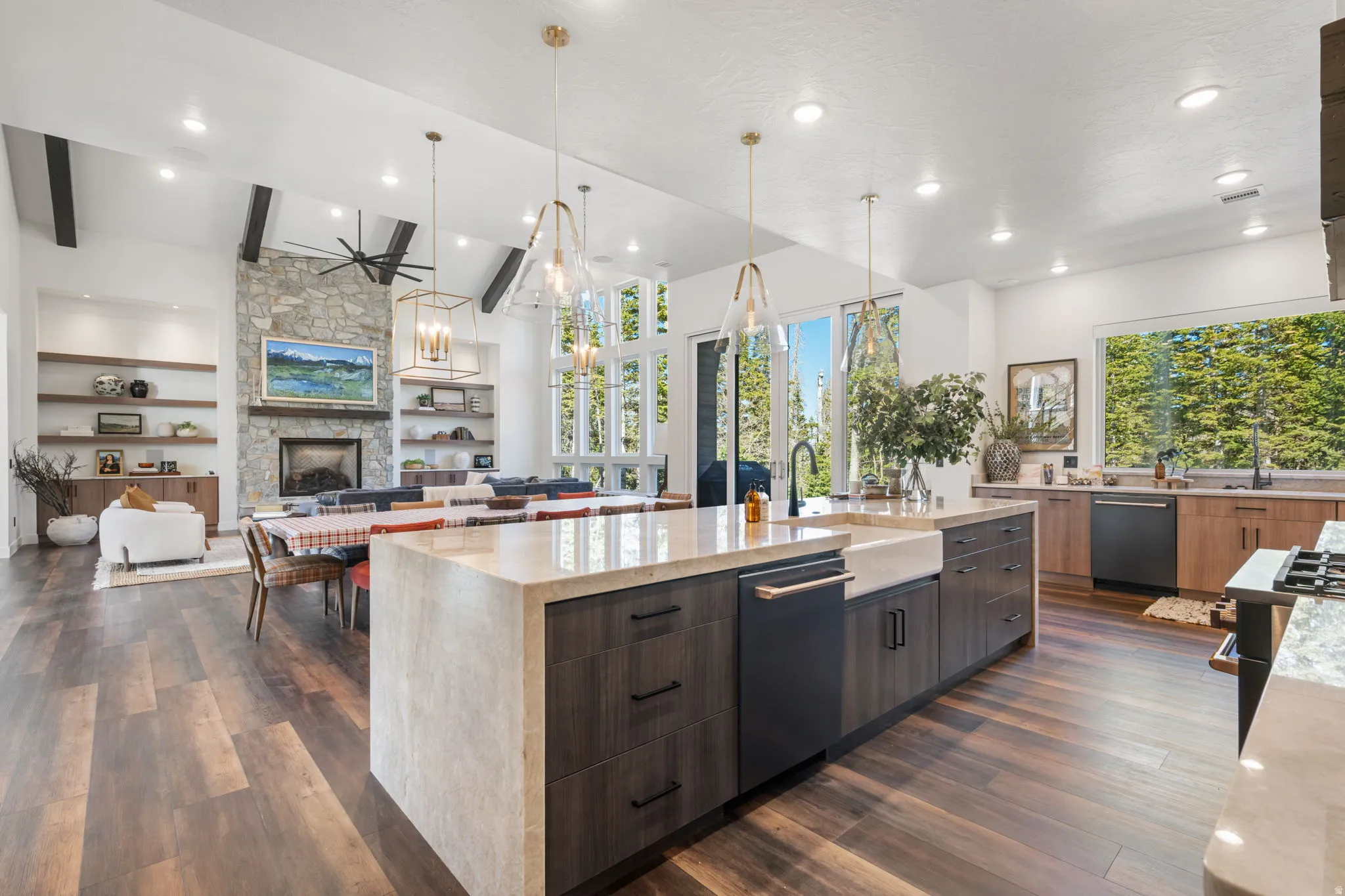 Kitchen featuring light stone counters, a large island, open floor plan, modern cabinets, and two tone cabinets