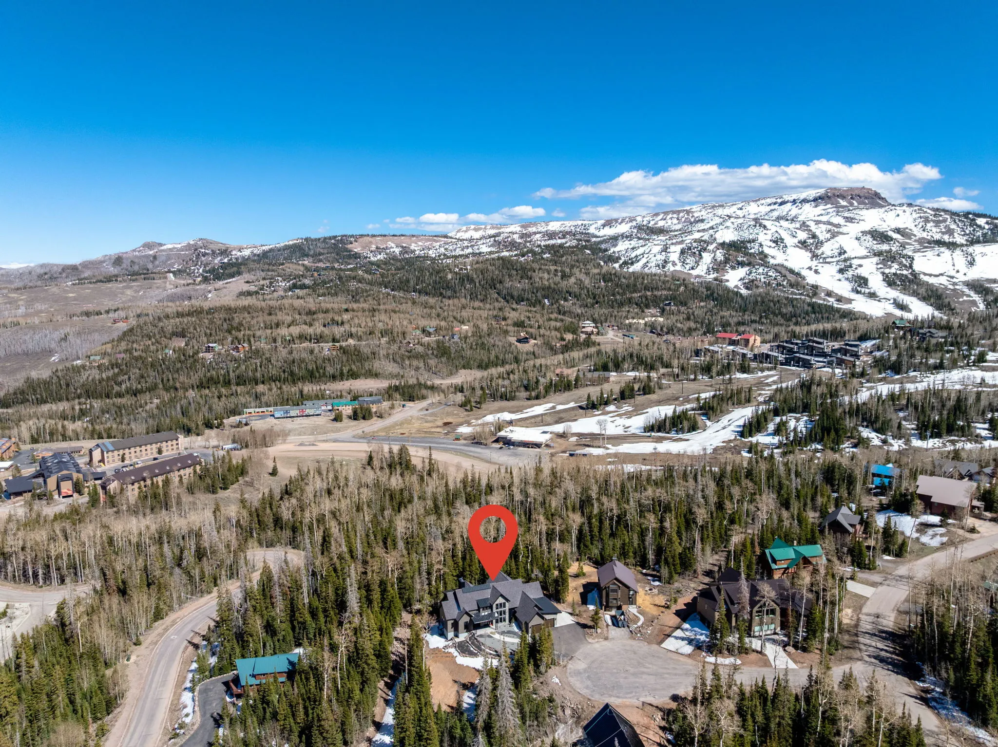 Aerial view of property and surrounding area featuring a mountain backdrop