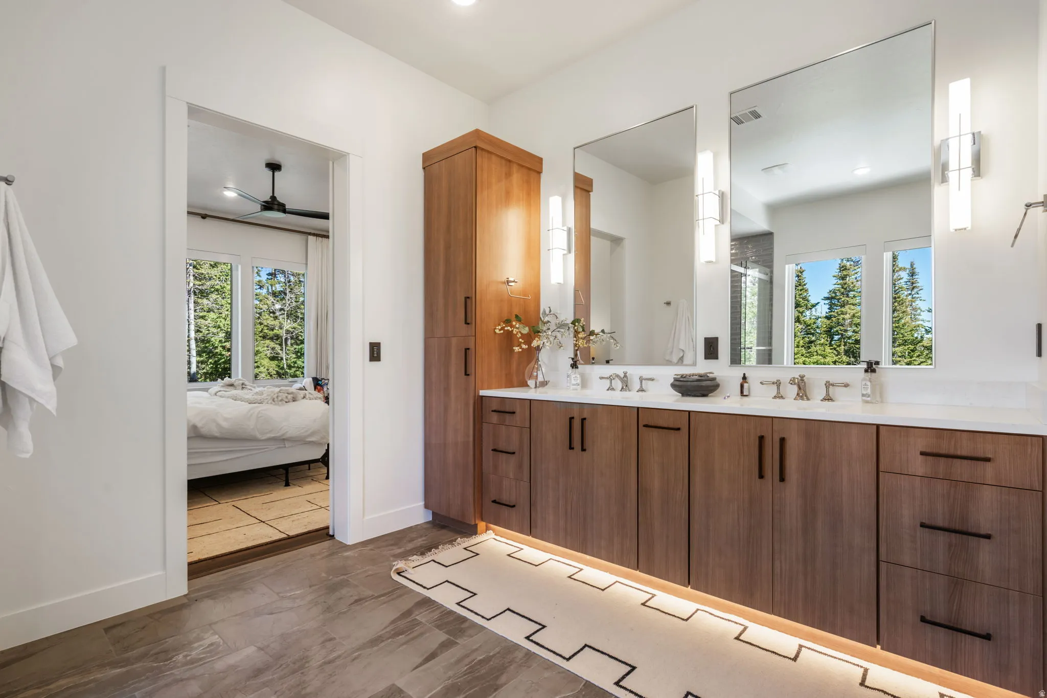 Ensuite bathroom with double vanity, a ceiling fan, and a stall shower