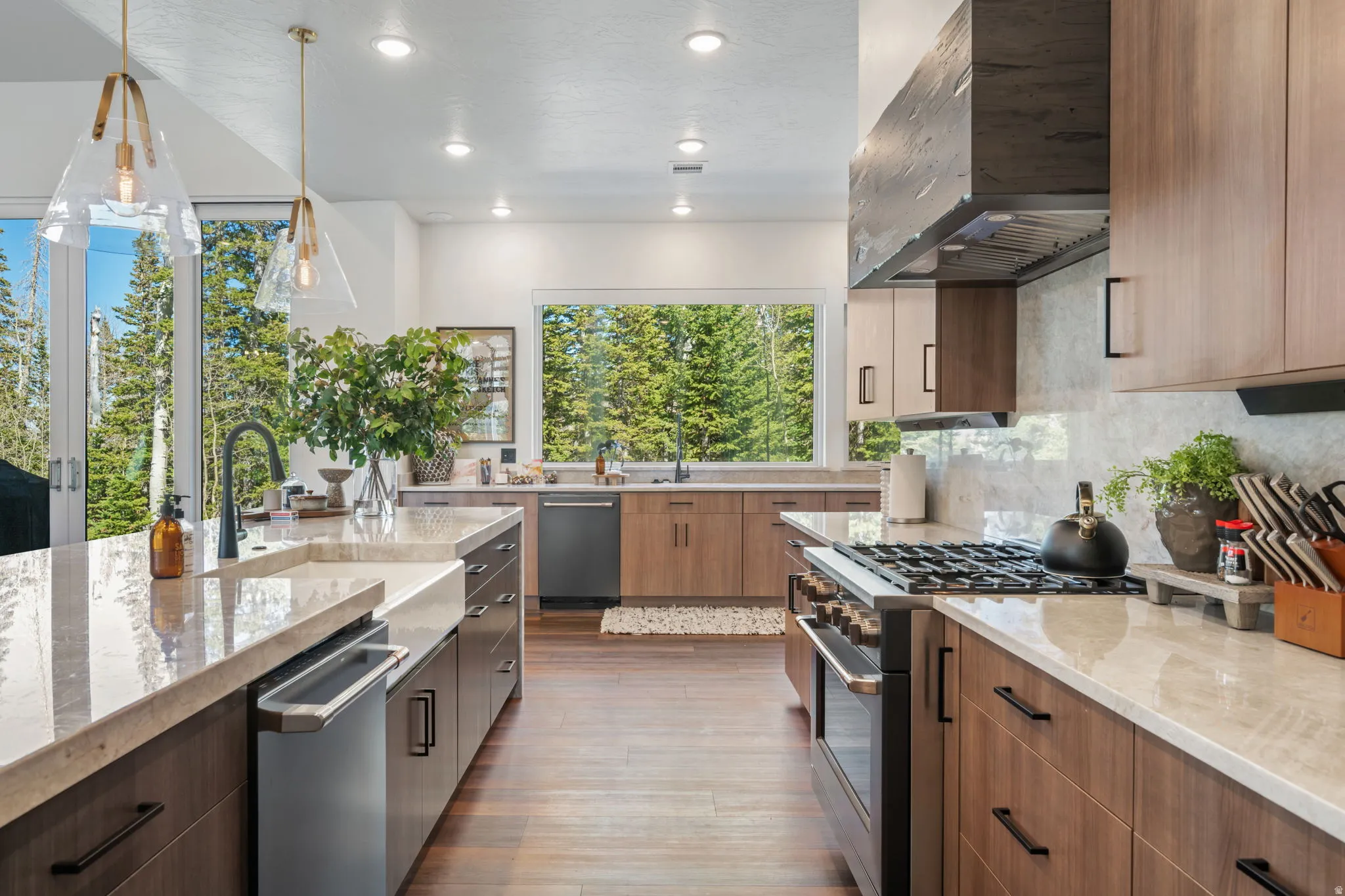 Kitchen featuring light stone countertops, stainless steel appliances, modern cabinets, light wood finished floors, and two tone color scheme