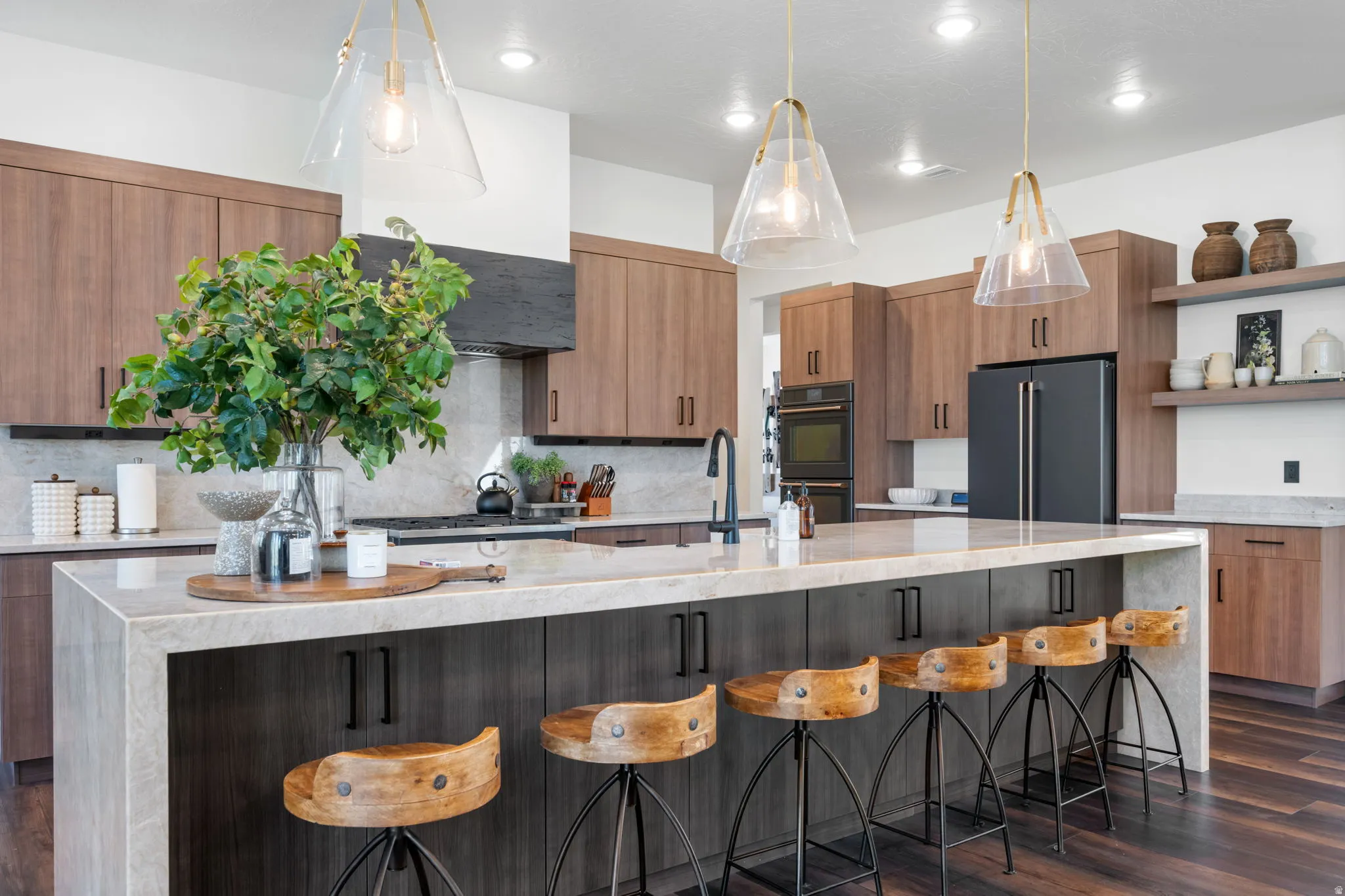 Kitchen with light stone counters, a breakfast bar area, modern cabinets, and pendant lighting