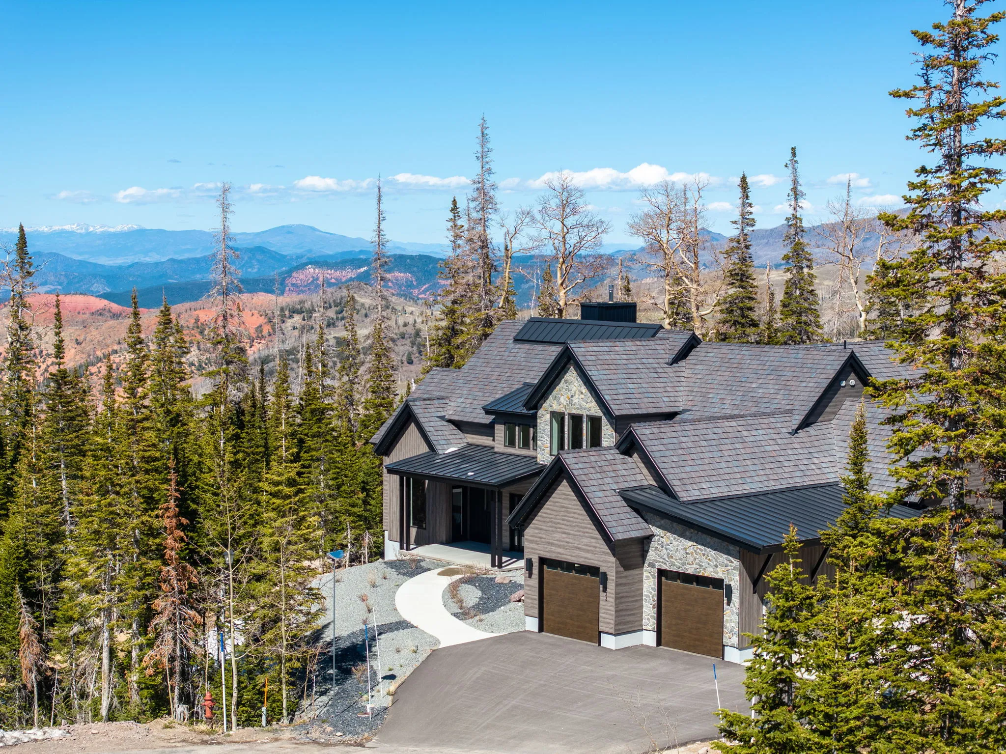 View of front of home featuring a standing seam roof, a mountain view, driveway, and a porch