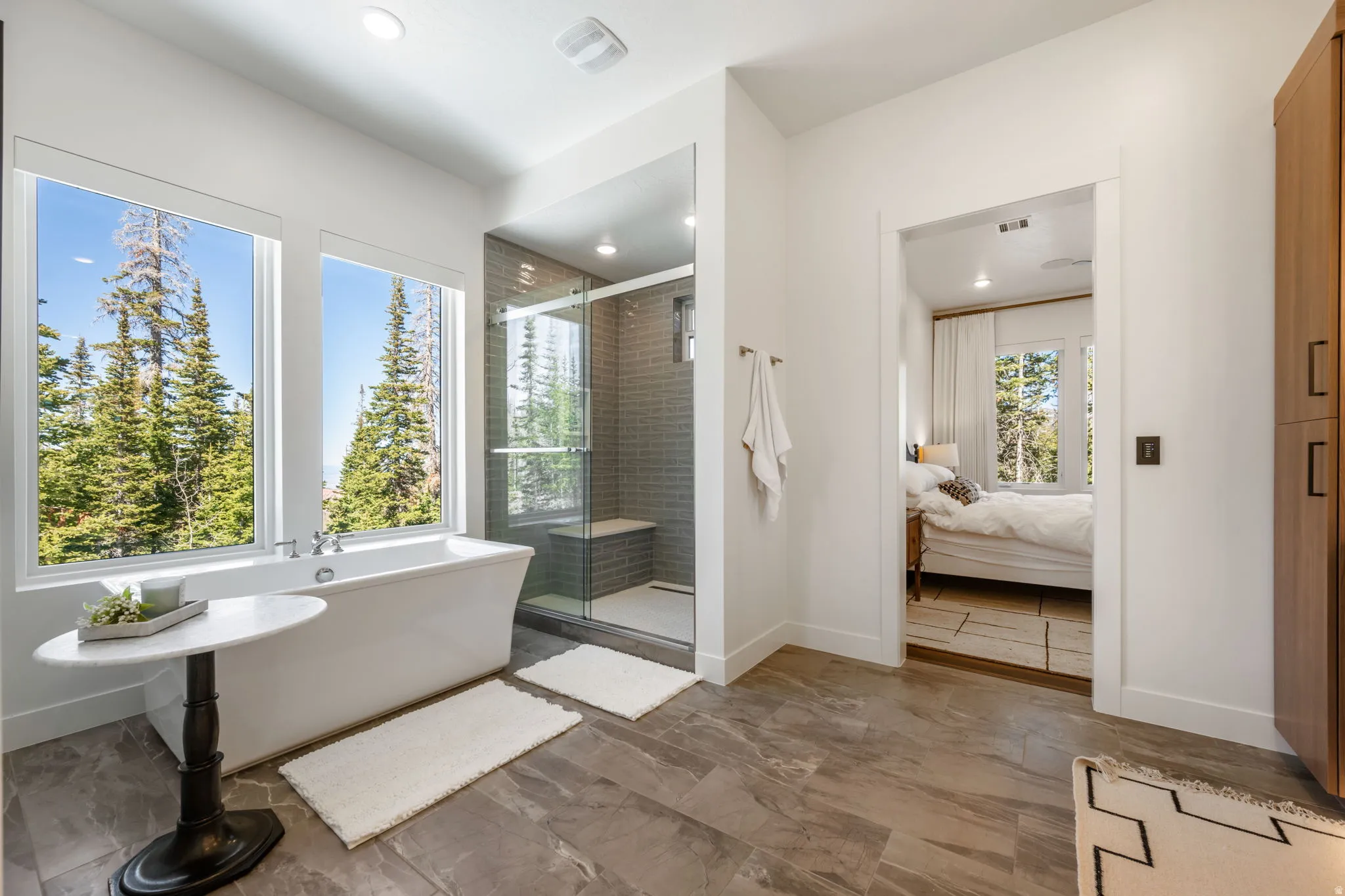 Bathroom with connected bathroom, a stall shower, a freestanding tub, and recessed lighting