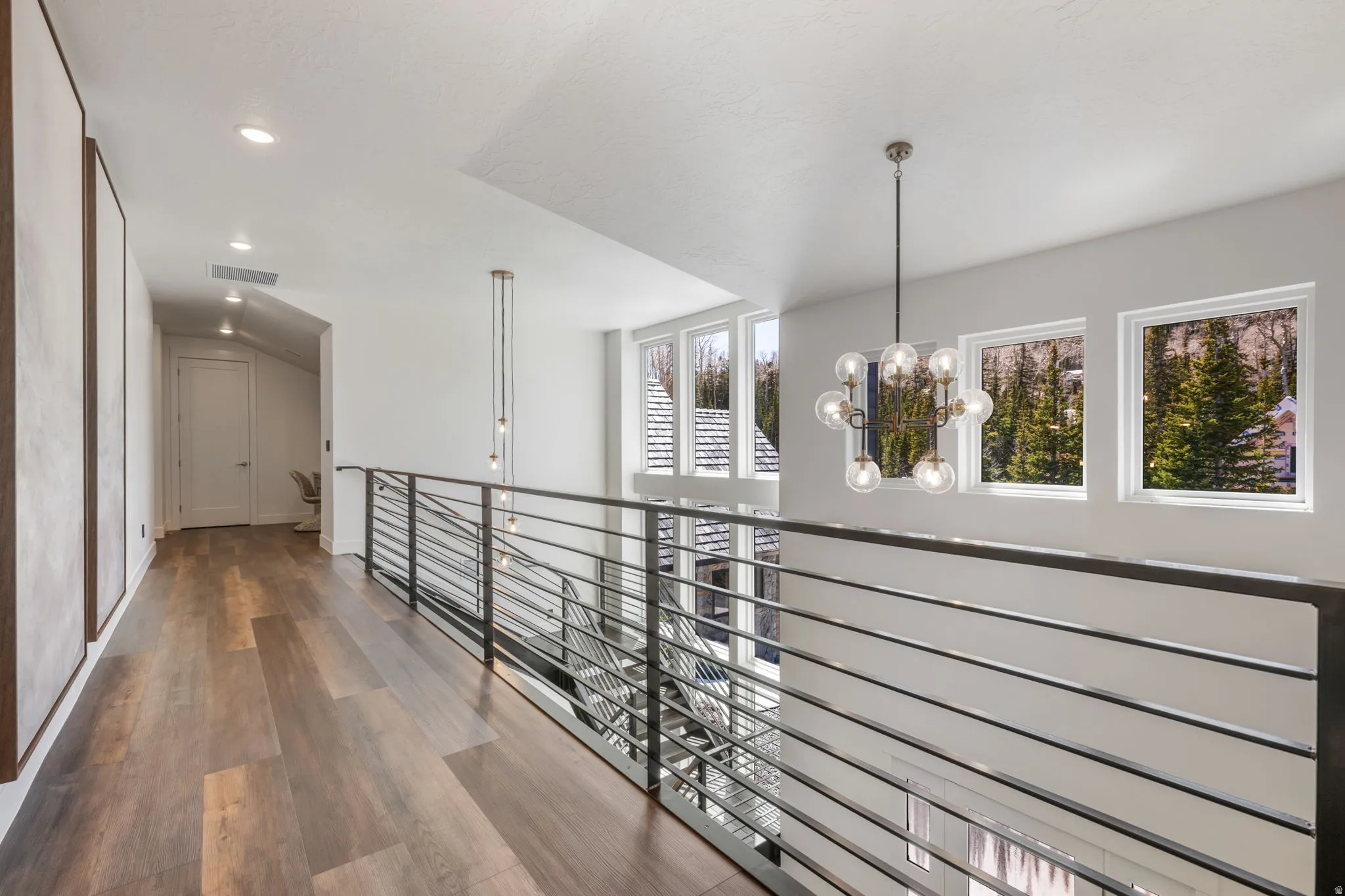 Hall featuring dark wood-style floors and a chandelier