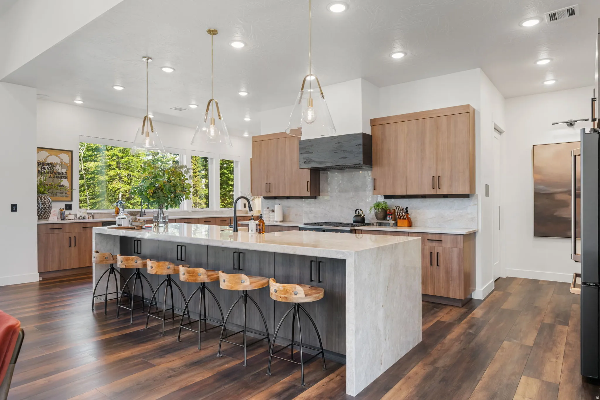 Kitchen featuring light stone countertops, dark wood-type flooring, pendant lighting, and freestanding refrigerator