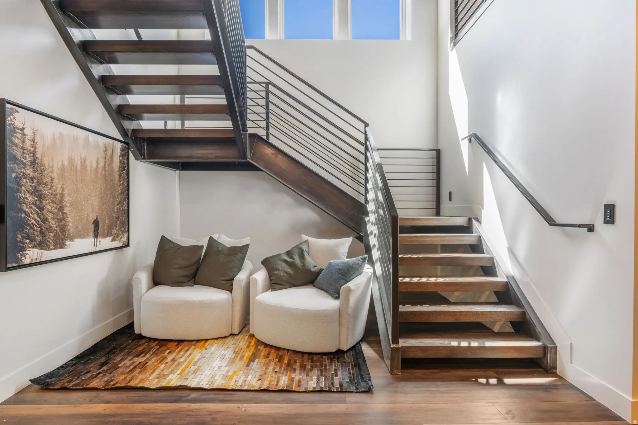 Stairs featuring wood finished floors and a high ceiling