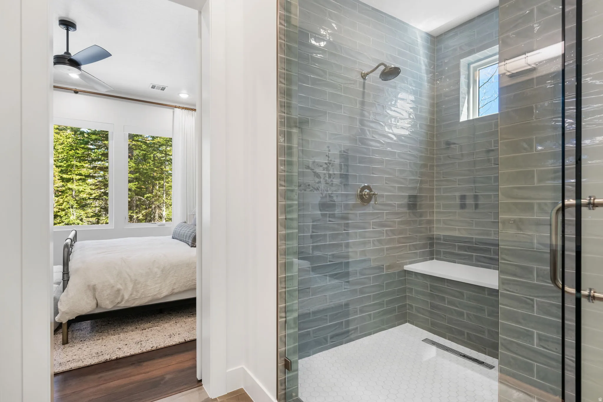 Bathroom featuring a stall shower, connected bathroom, wood finished floors, and ceiling fan