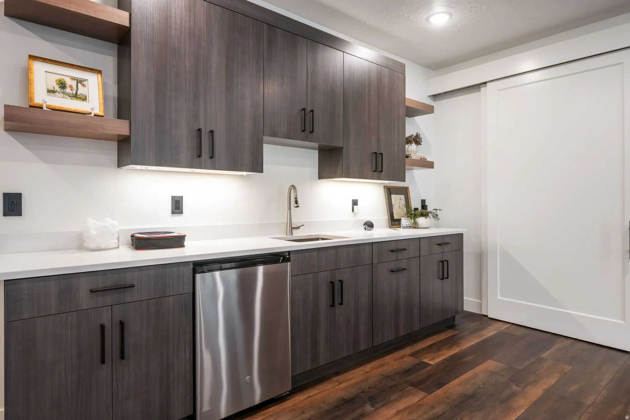 Kitchen with open shelves, dark wood finish cabinets, and stainless steel dishwasher