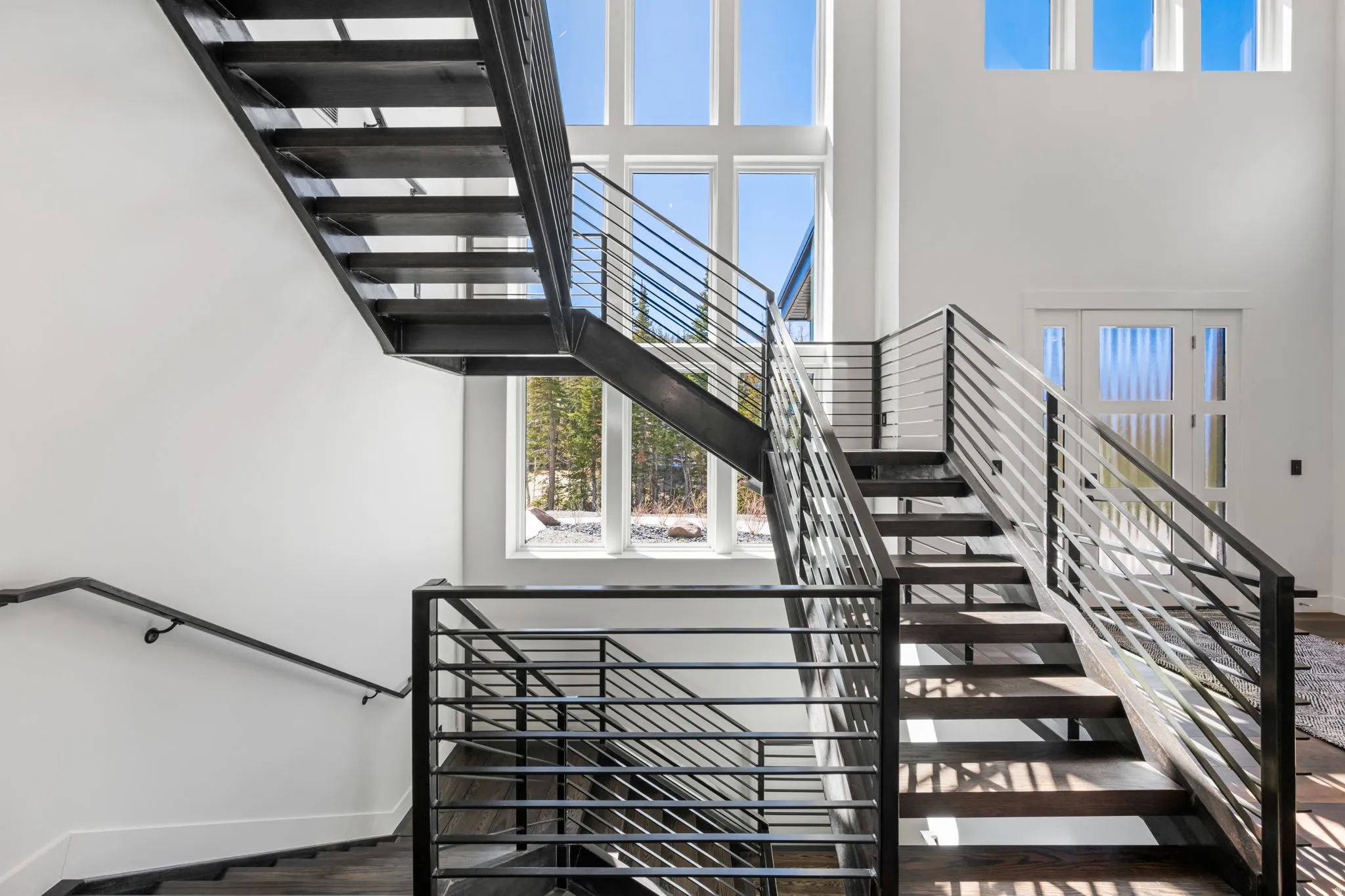 Stairway with a high ceiling and wood finished floors