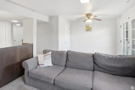 Living area featuring a ceiling fan and carpet floors