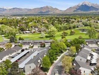 Aerial perspective of suburban area featuring a golf club and a water and mountain view