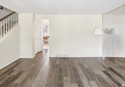 Unfurnished living room featuring dark wood-style floors