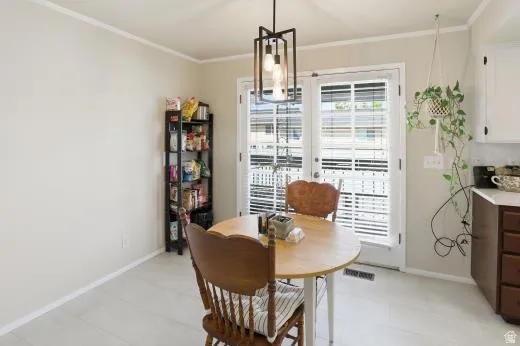 Dining room with crown molding, french doors, and light flooring