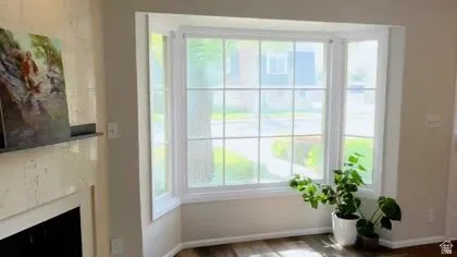 Doorway to outside with a fireplace and wood finished floors