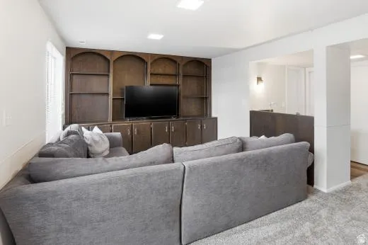 Carpeted living room featuring built in features and baseboards