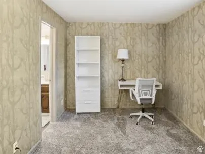 Office space with carpet flooring and wallpapered walls