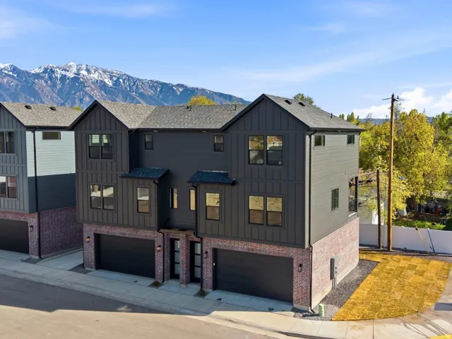 Modern inspired farmhouse featuring a garage, board and batten siding, a mountain view, and concrete driveway