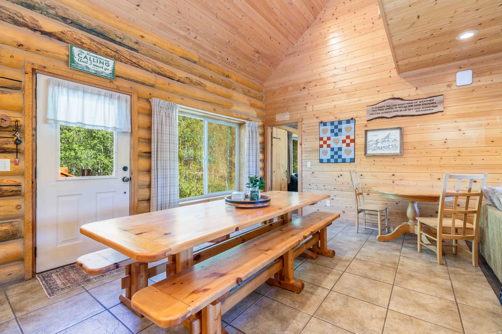 Dining space featuring a vaulted wooden ceiling and light tile patterned flooring