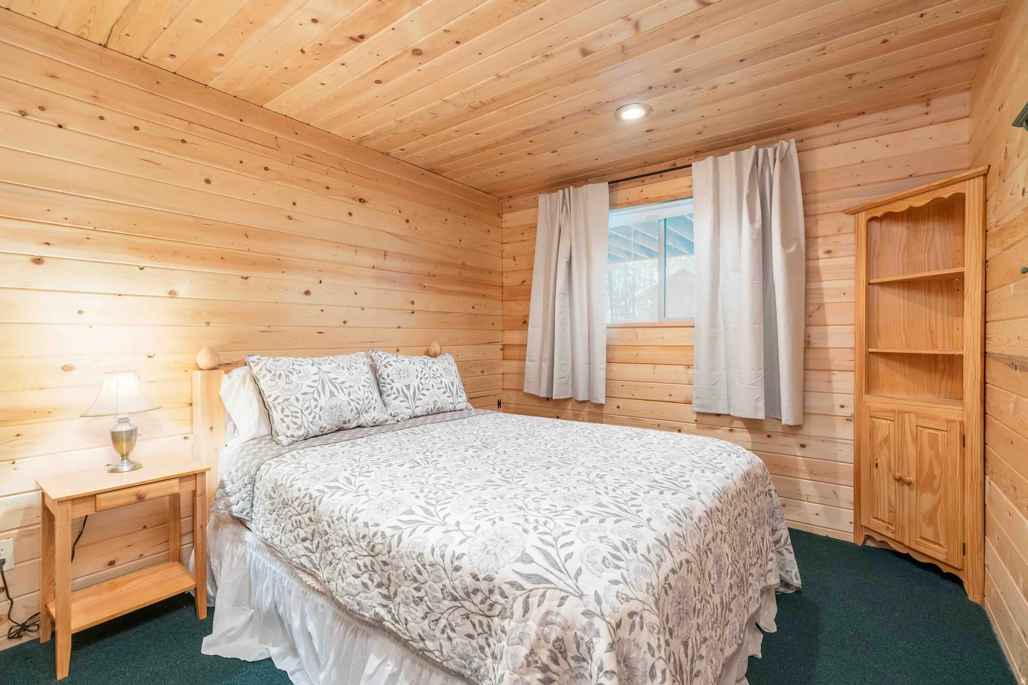 Bedroom with wooden walls, carpet floors, wood ceiling, and recessed lighting