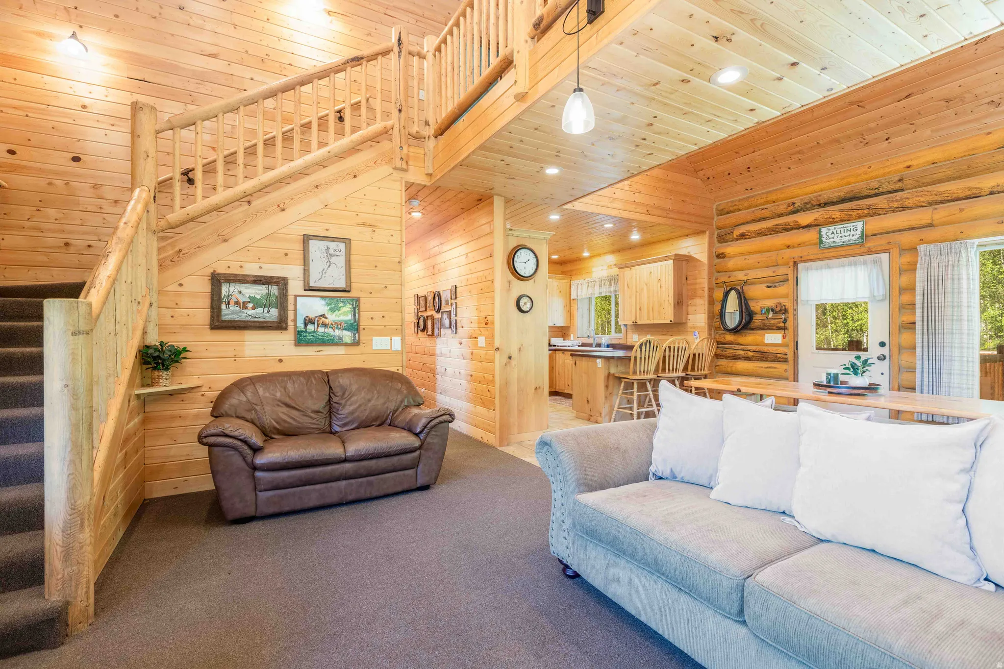 Living area featuring healthy amount of natural light, recessed lighting, a high wooden ceiling, wooden walls, and carpet