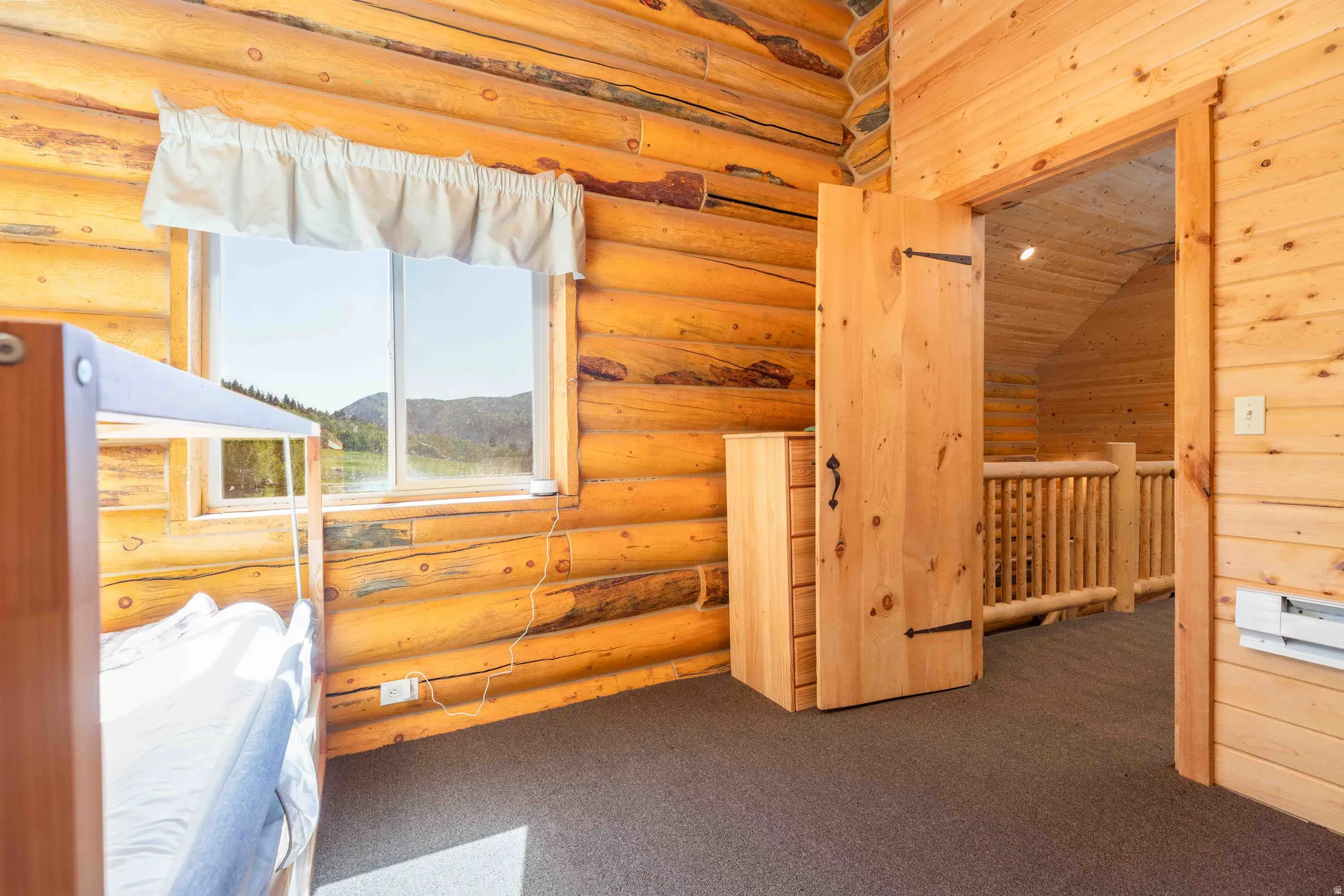 Unfurnished bedroom featuring carpet and rustic walls