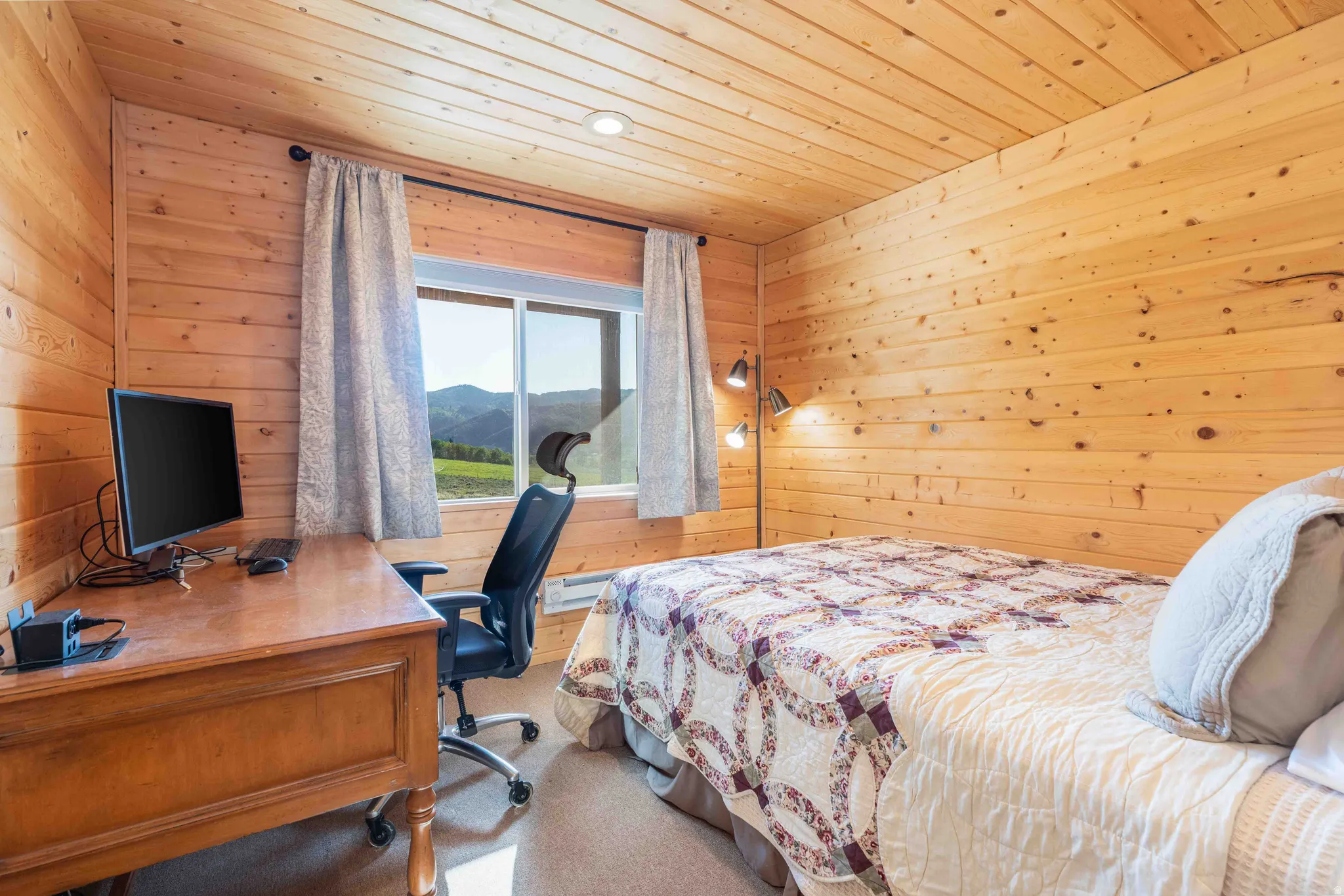 Carpeted bedroom featuring wood walls, a desk, and wood ceiling