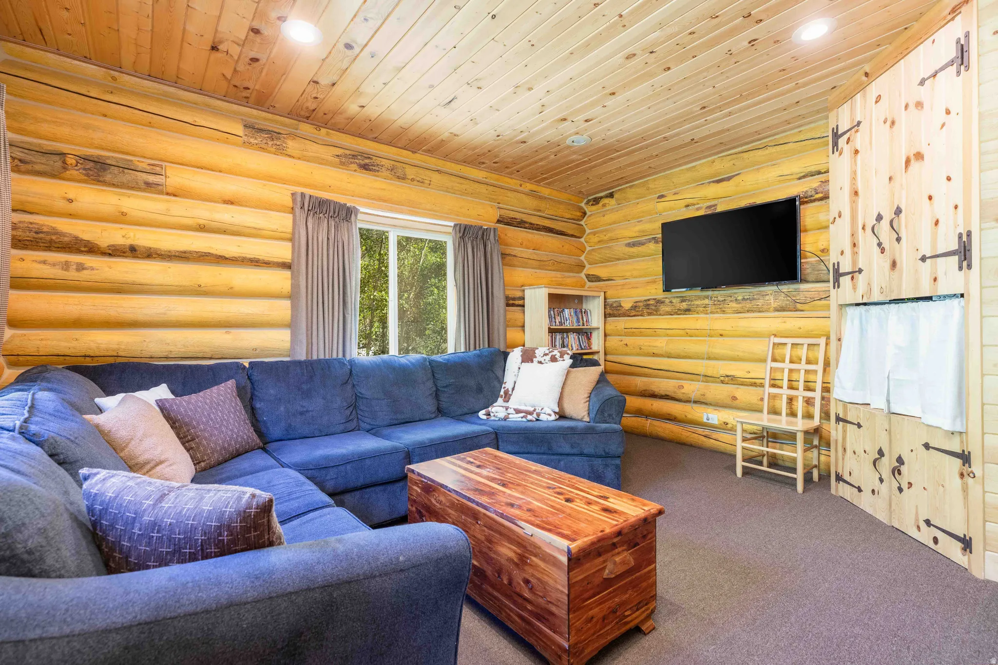 Carpeted living area featuring wood ceiling, rustic walls, and recessed lighting