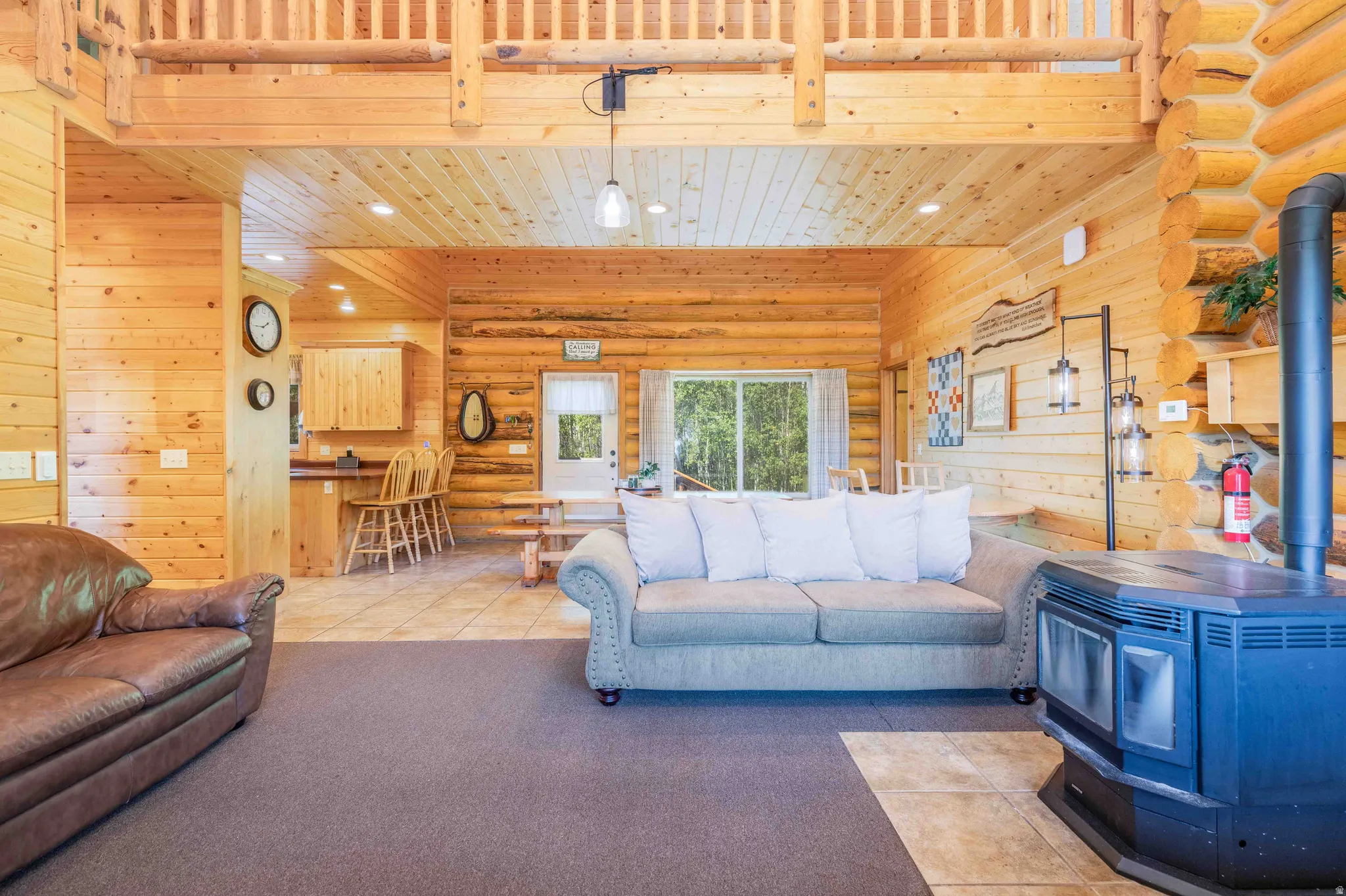 Living area featuring a wood stove, recessed lighting, log walls, light colored carpet, and light tile patterned floors