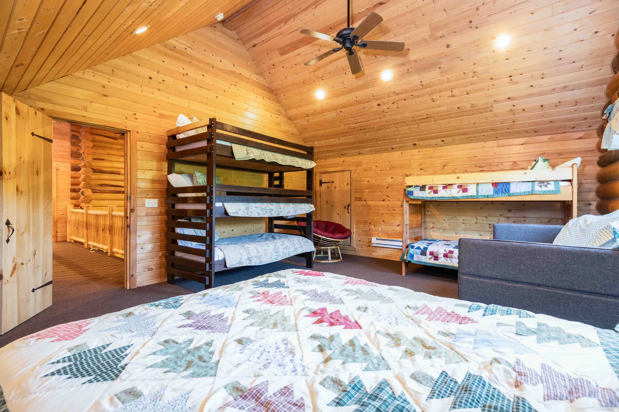 Bedroom with wooden walls, dark carpet, a ceiling fan, recessed lighting, and a vaulted wood ceiling