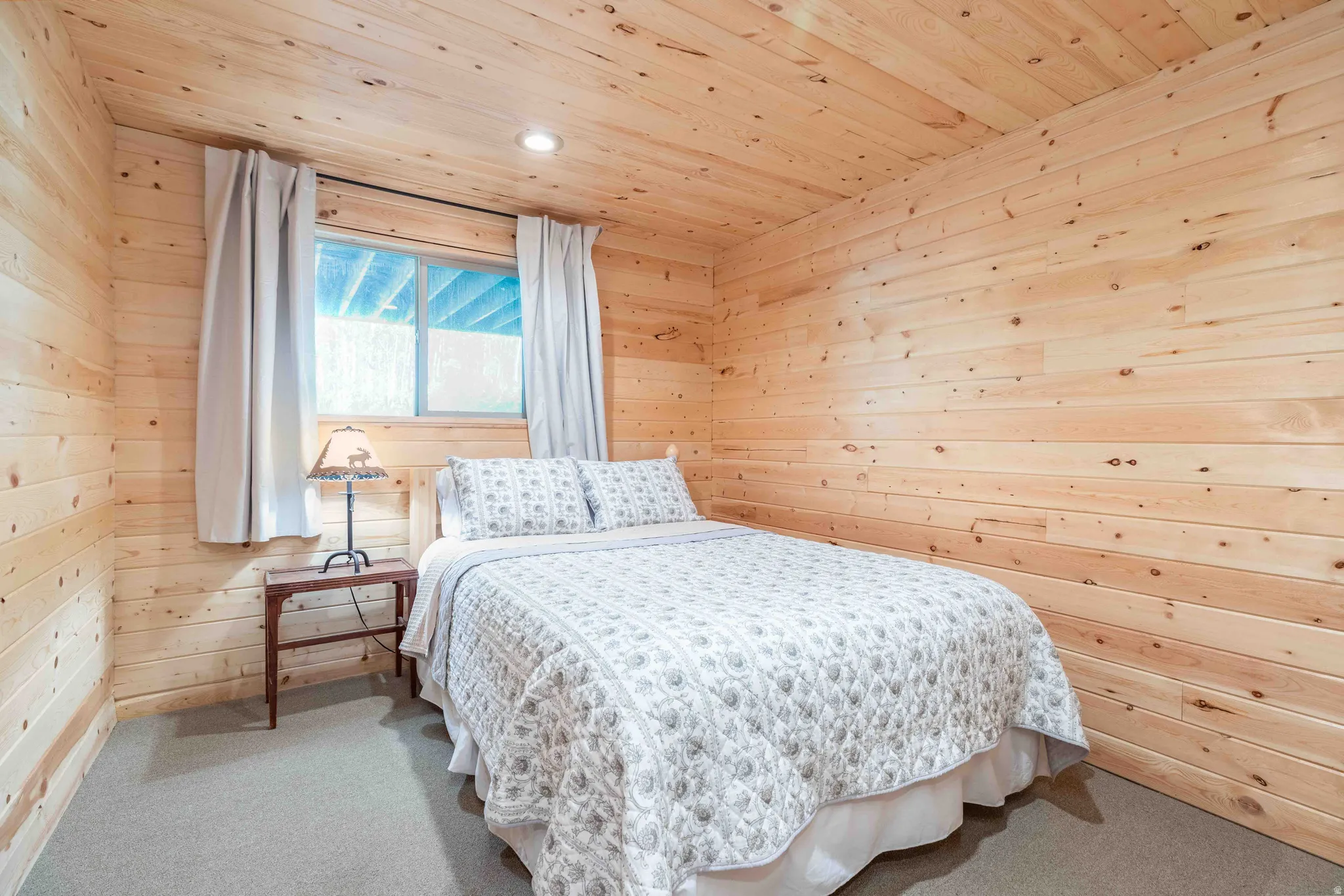 Bedroom featuring wood walls, wood ceiling, carpet flooring, and recessed lighting