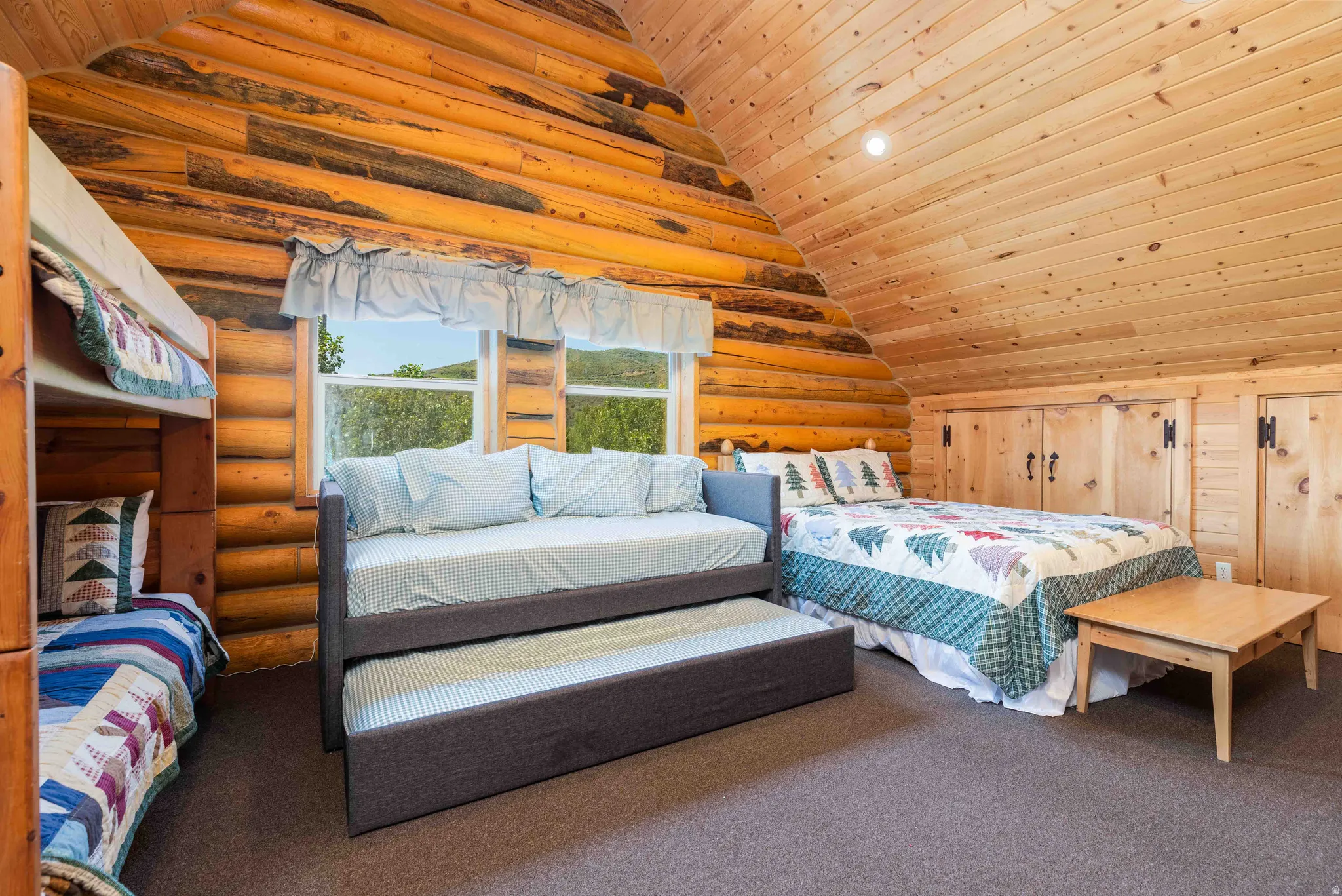 Bedroom with a vaulted wood ceiling, rustic walls, carpet floors, and wood walls