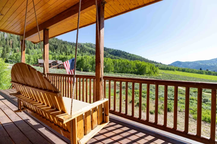 Deck with a wooded view and a mountain view