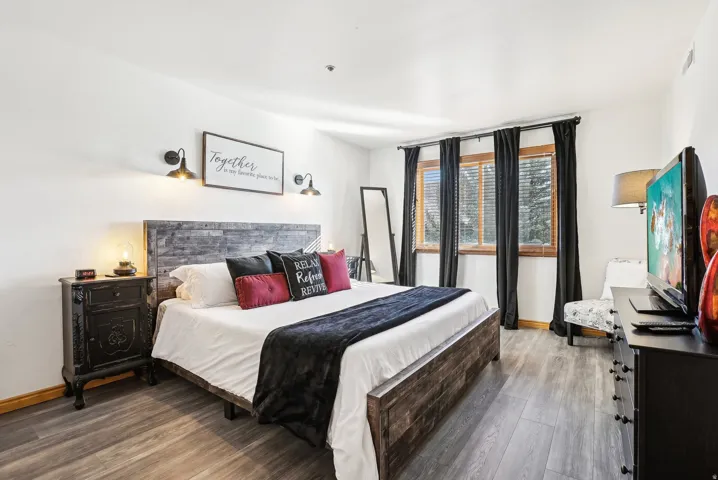 Bedroom with dark wood finished floors and baseboards