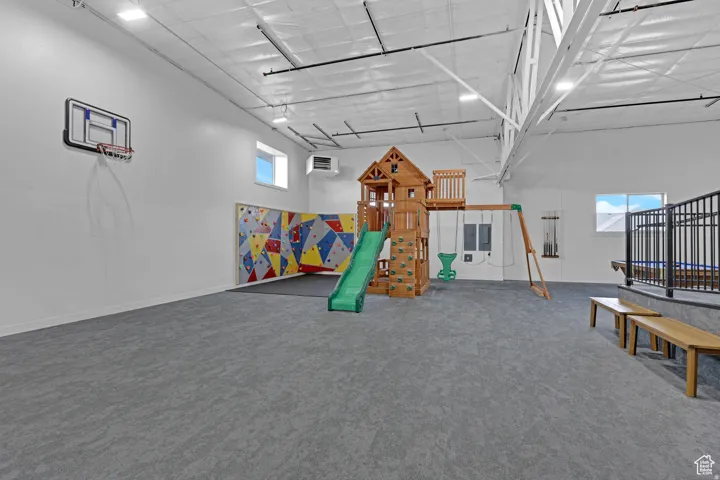 Recreation room with healthy amount of natural light, a high ceiling, and a heating unit