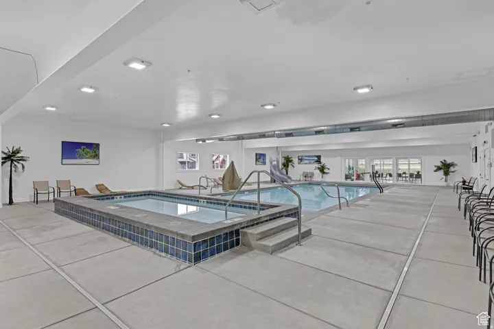 Indoor pool featuring a hot tub