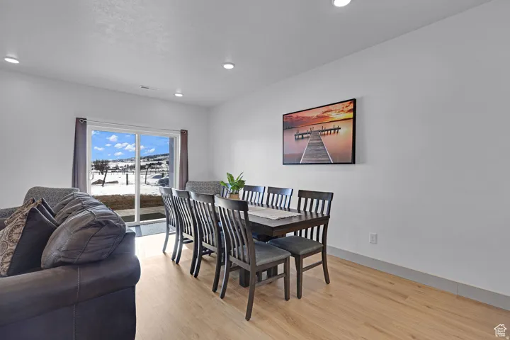 Dining room with light wood-style floors and recessed lighting