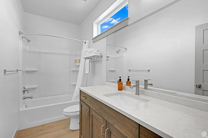 Bathroom with vanity, light wood-style floors, and shower / tub combo