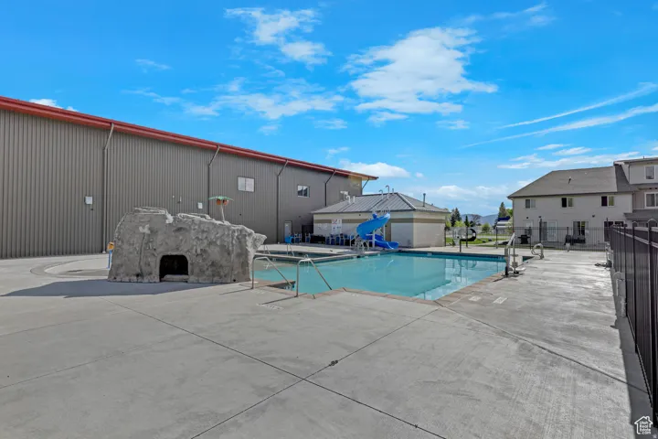Community pool with a patio area and a residential view