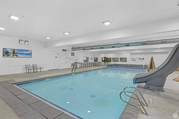 Indoor community pool featuring a water slide