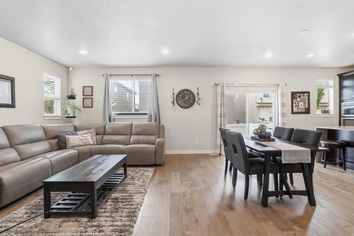 Living room featuring light wood-type flooring, a textured ceiling, and recessed lighting