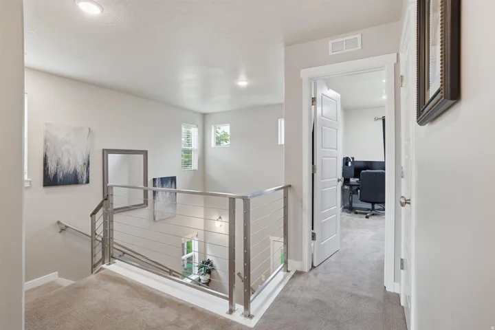 Hall featuring an office area, an upstairs landing, light carpet, and recessed lighting