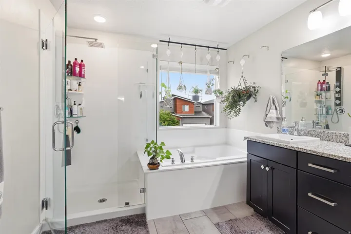 Bathroom with a bath, a stall shower, and vanity