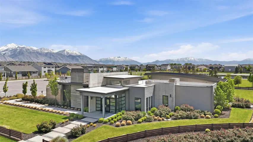 Rear view of property with a residential view, a yard, and a mountain view