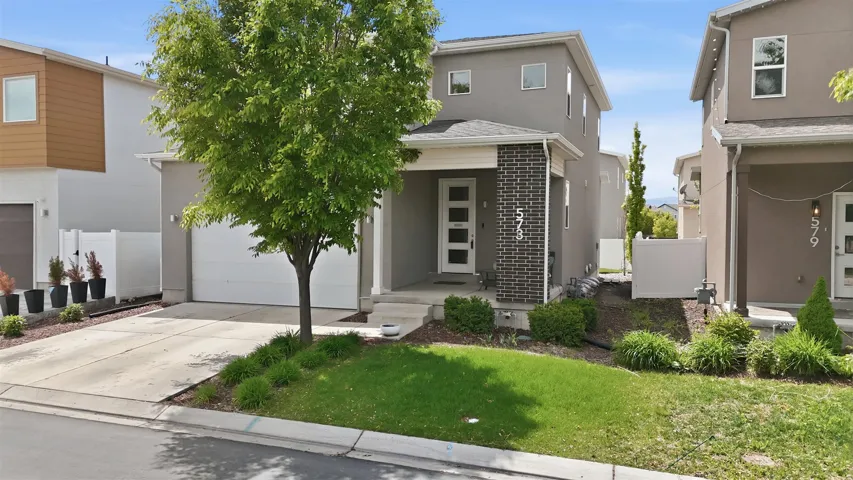 Contemporary house featuring concrete driveway and stucco siding