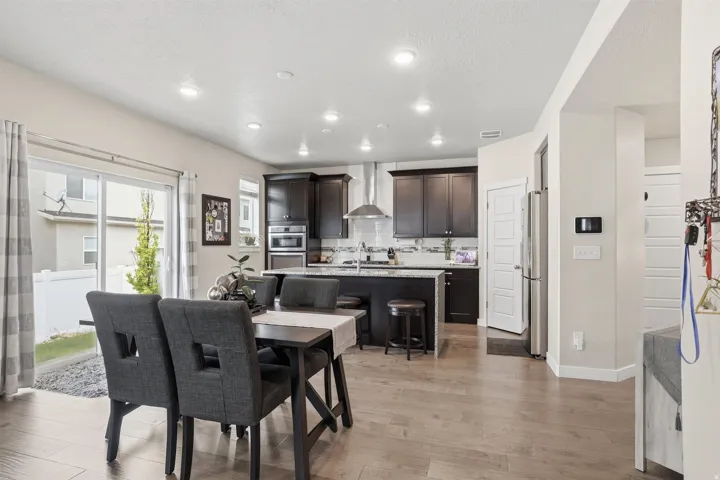 Dining area featuring light wood finished floors, a textured ceiling, and recessed lighting