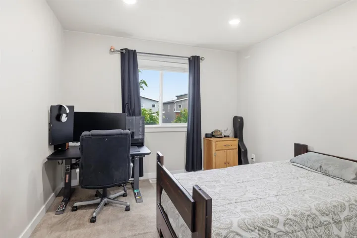 Bedroom featuring an office area and light colored carpet