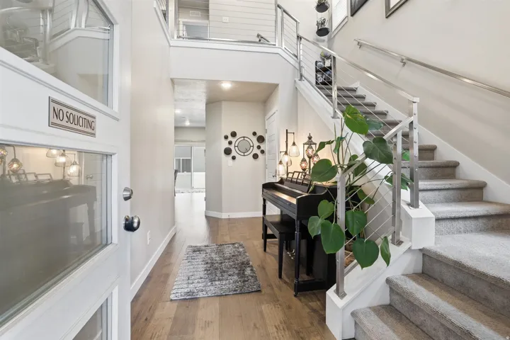 Stairway featuring a high ceiling, wood finished floors, and recessed lighting