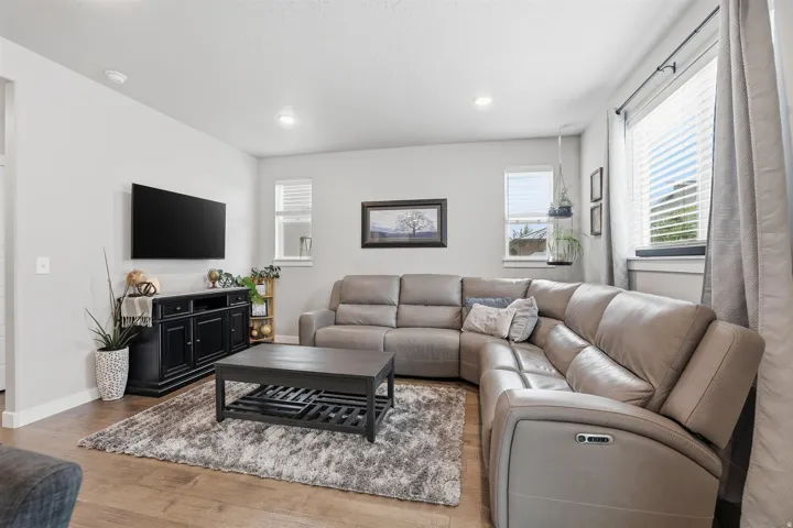 Living room with light wood-type flooring and recessed lighting