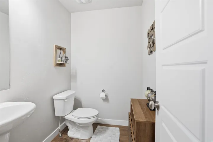 Half bath featuring wood finished floors and a textured ceiling